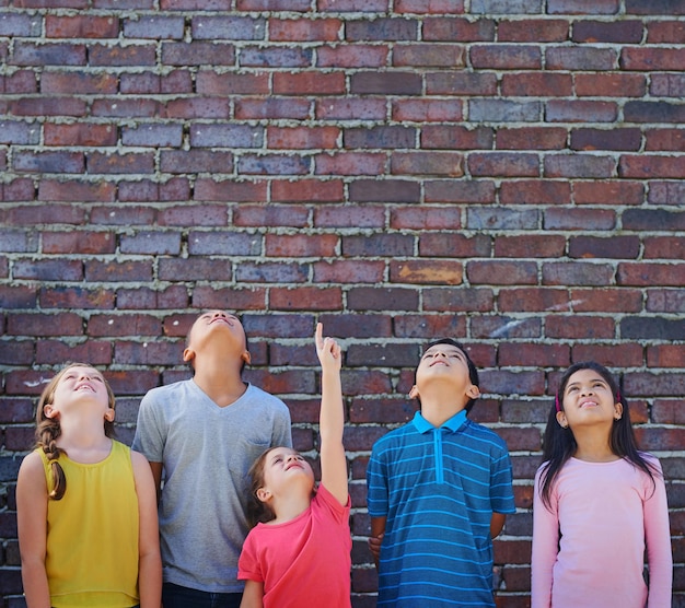 Education will take us higher Shot of a diverse group of children looking up outside