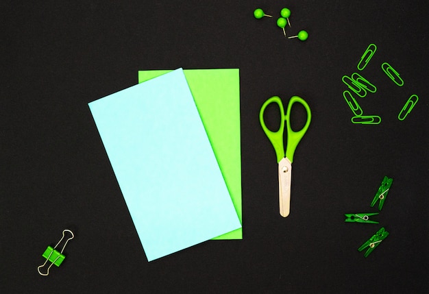 Educational composition, stationery. Green stationery and green notebook on black 