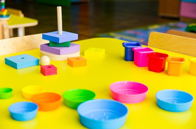 Educational toy pyramid on a yellow table Concept of child development and learning