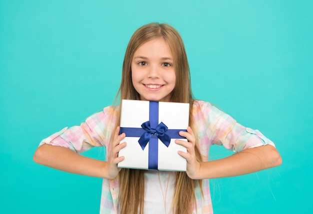 Een aangenaam cadeau Kleine shopaholic met cadeau verpakt in doos Klein kind met geschenkdoos vastgebonden met strik Leuke shopper geniet van een beetje winkelen Klein meisje na het winkelen voor een cadeau