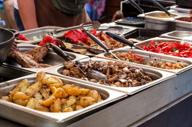 Een aanrecht met metalen dienbladen met gegrild voedsel. eten en koken apparatuur op een straatvoedsel festival