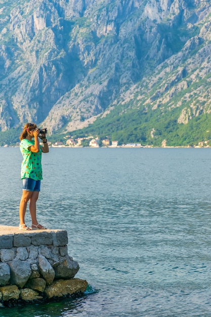 Een aantrekkelijk meisje neemt foto's van het zeegezicht.