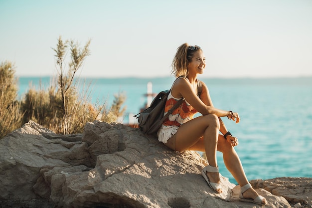 Een aantrekkelijke jonge vrouw die geniet van een zomervakantie terwijl ze de prachtige kust van de Middellandse Zee verkent.