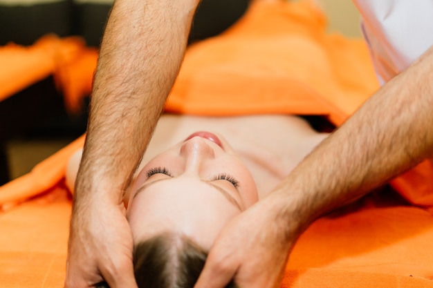 Een aantrekkelijke Latijns-Amerikaanse vrouw liggend op een massagebed in een spa