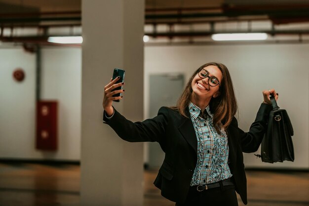 Een aantrekkelijke zakenvrouw in een pak en een koffer die een foto maakt voor sociale netwerken met een smartphone. Selectieve aandacht. Foto van hoge kwaliteit