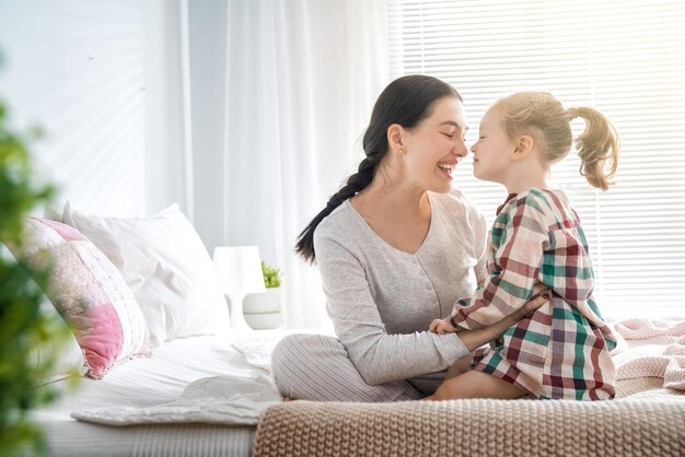 Een aardig babymeisje en haar moeder genieten van zonnige ochtend. Lekker thuis.