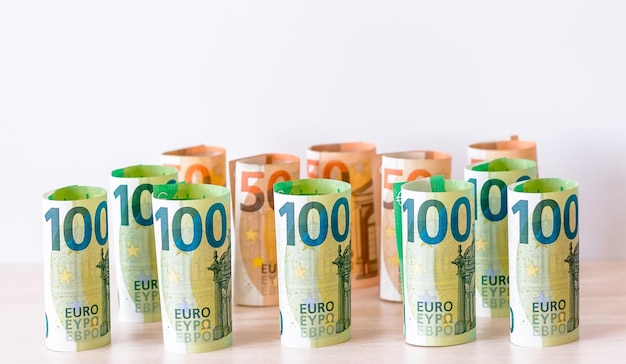Een achtergrond bestaande uit papiergeld in coupures van 100 en 50 euro gevouwen tot een rol