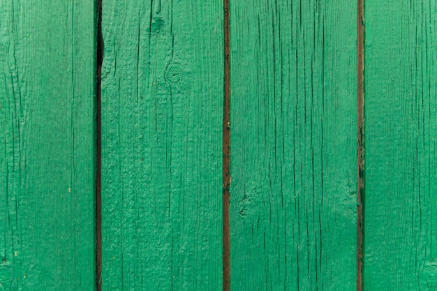 Een achtergrond van groene afbladderende verf op een oude houten muur Ongelijke textuur van de planken