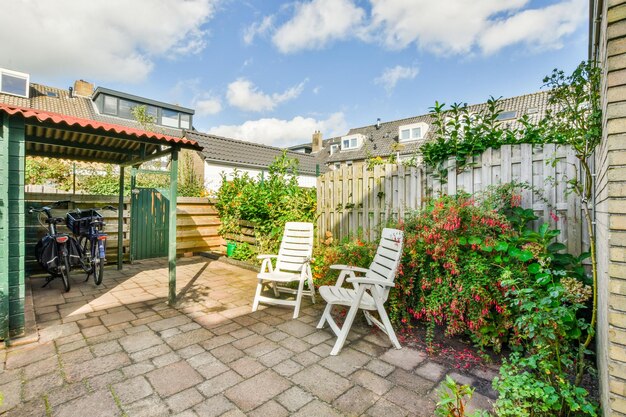 Foto een achtertuin met twee stoelen en een schutting en planten