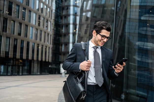 Een advocaat gebruikt een telefoon om een bericht te schrijven aan een collega een man met een bril gaat naar kantoor
