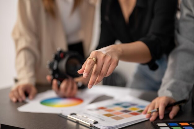 Een afgekapte afbeelding van een professionele ervaren vrouwelijke fotograaf die met haar team in de studio werkt