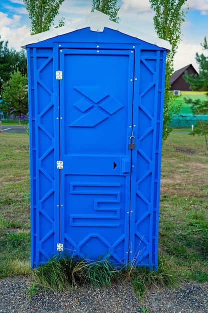 Een afgesloten openbaar blauw plastic toilethokje staat op straat