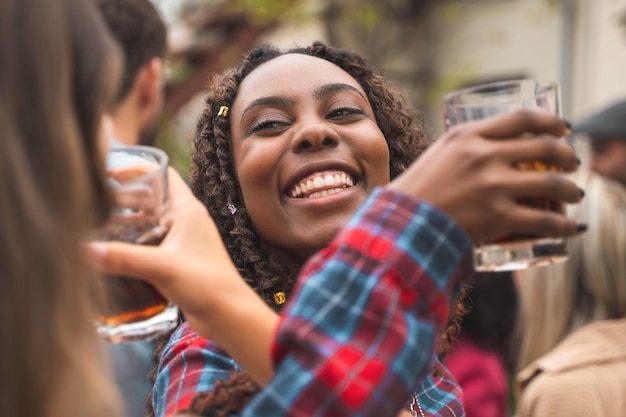 Een Afrikaans meisje heeft plezier met dansen en drinken op het eindejaarsfeest van Erasmus op het terras van het hostel