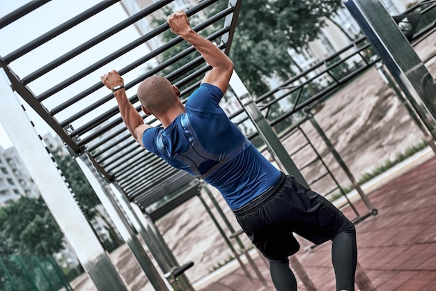 Een Afrikaanse man oefent in de openluchtgym