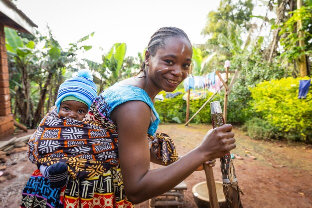 Een Afrikaanse moeder met haar pasgeboren zoon in de Afrikaanse tribale kleding van het dorp