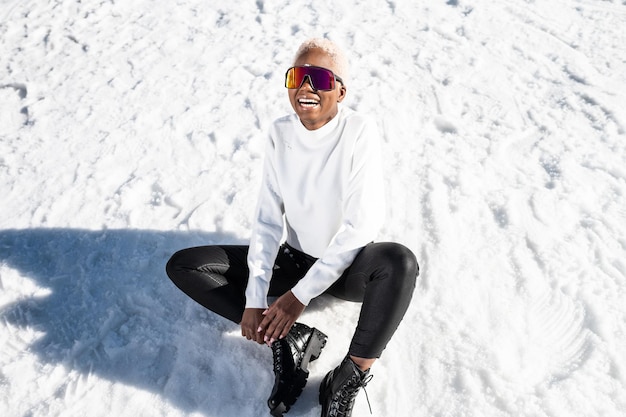 Foto een afro-amerikaanse vrouw die in de winter een sneeuwbril draagt op een besneeuwde berg