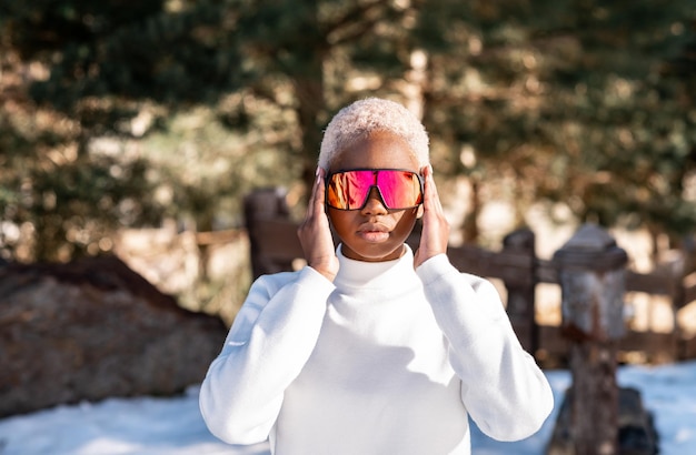 Een Afro-Amerikaanse vrouw die in de winter een sneeuwbril draagt op een besneeuwde berg