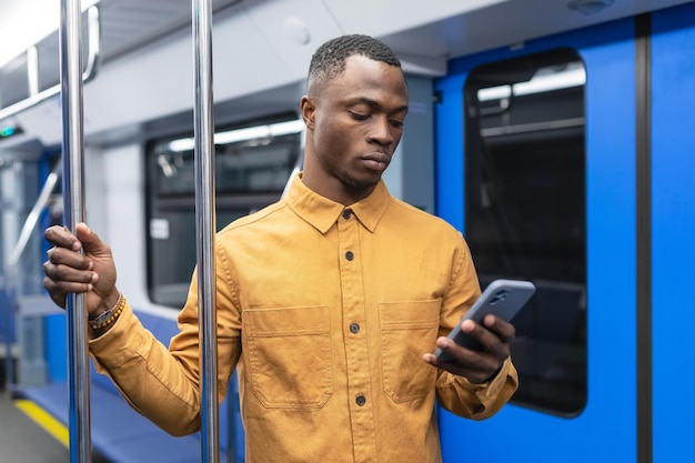 Een Afro-Amerikaanse zakenman met een mobiele telefoon rijdt in de metro en lost zakelijke problemen op