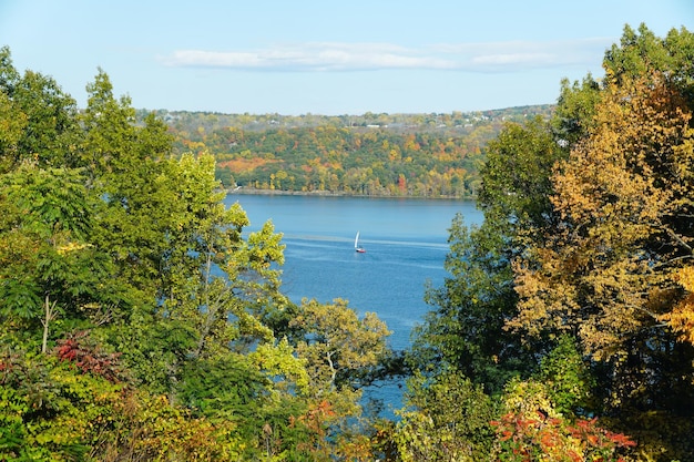 Een afstandsbeeld van een zeilboot met de achtergrond van herfstbladeren bij Cayuga Lake New York