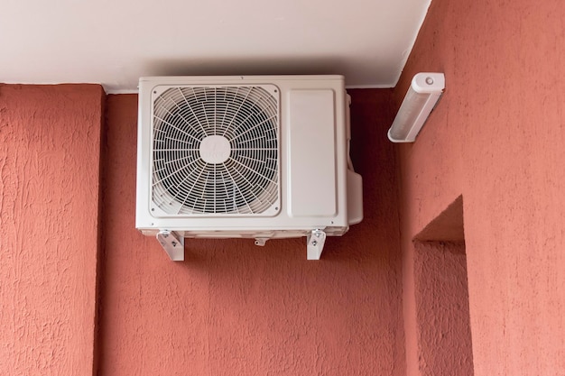 Een airconditioningsysteem geïnstalleerd buiten op de muur van een bakstenen gebouw Ventilatie en airconditioning van woningen