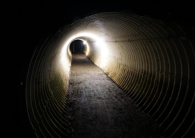 Foto een angstaanjagende, zwak verlichte tunnel daagt de dappere uit om door te gaan naar het onbekende.