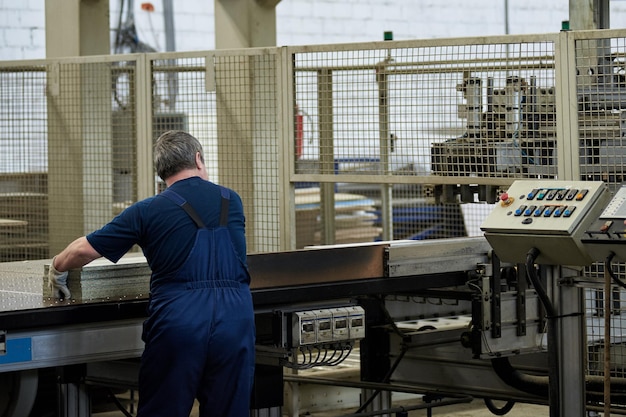 Een arbeider verwerkt meubelspaties op een werktuigmachine in een fabriek. industriële productie van meubels.