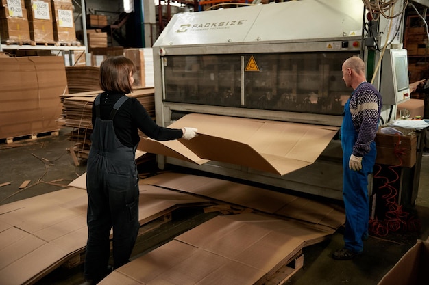 Een arbeider verwerkt meubelspaties op een werktuigmachine in een fabriek. Industriële productie van meubels.