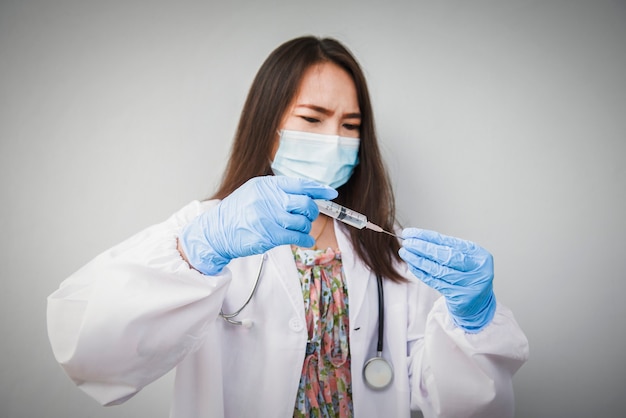 Foto een arts die een beschermend medisch masker draagt, bereidt zich voor om te injecteren met het coronavirusvaccin, vaccinatie en immunisatie