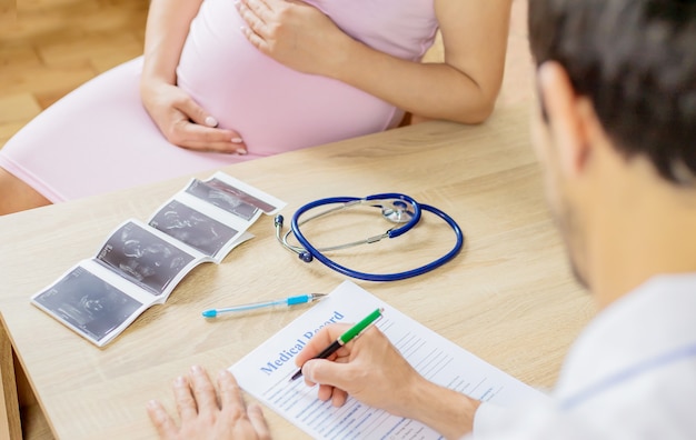 Een arts in een kliniek onderzoekt een zwangere vrouw