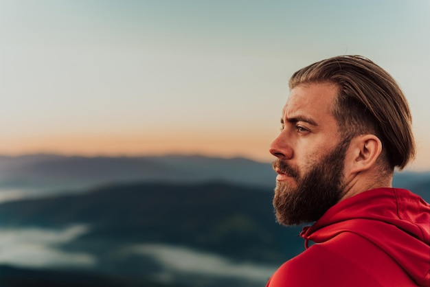 Een atleet rust op de top van een berg na een uitputtende hardlooptraining.