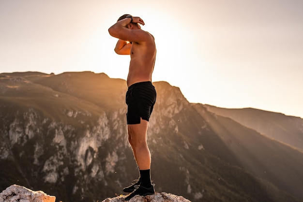 Een atleet rust op de top van een berg na een uitputtende hardlooptraining.