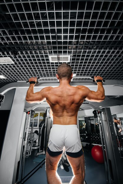 Een atleet voert pull-ups uit in de sportschool