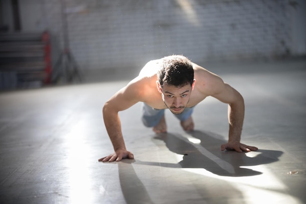 Een atletische man op capoeira-training die push-ups doet