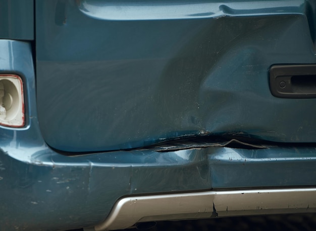 Een auto met een gedeukte bumper is beschadigd geraakt bij een verkeersongeval