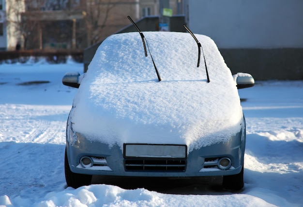 Een auto op de straat van een stad bedekt met sneeuw in het winterseizoen.