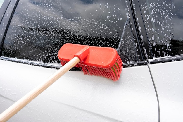 Een auto schoonmaken met een borstel