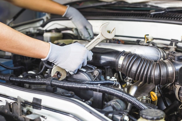 Een automonteur doet een autoreparatie in een reparatiewerkplaats.