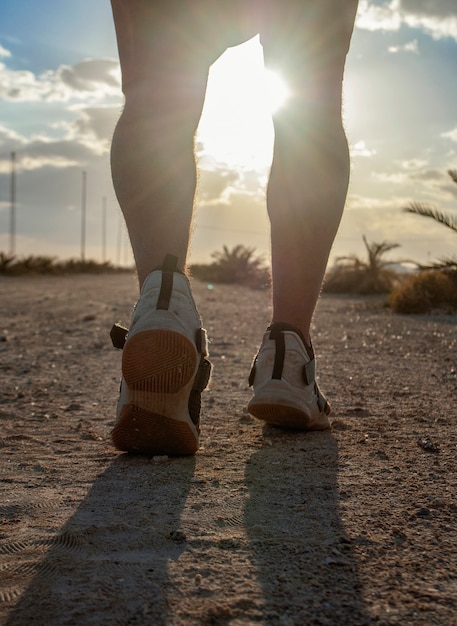 Een avond joggen of een man rent langs de weg op het strand.