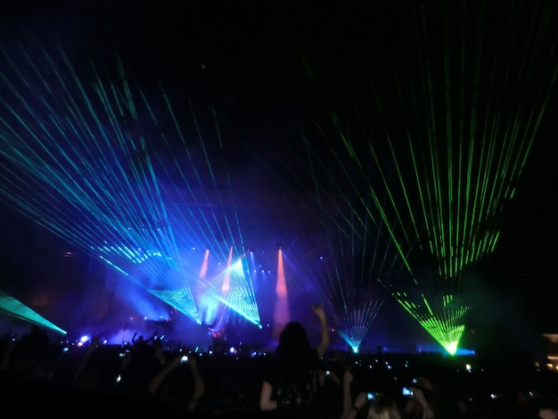 Een avond rockconcert voor een groot publiek in een openluchtstadion met een lasershow