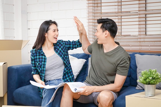 Foto een aziatisch stel hand in hand dat zich verheugt over het bouwen van een nieuw huis verhuizen naar een nieuw huis familie concept onroerend goed bedrijf