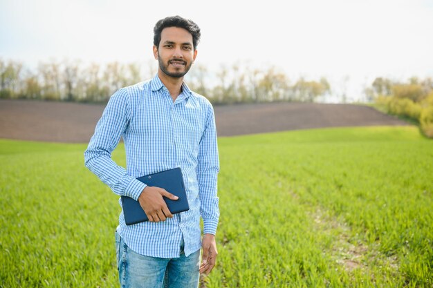 Een Aziatische boer staat in een rijstveld
