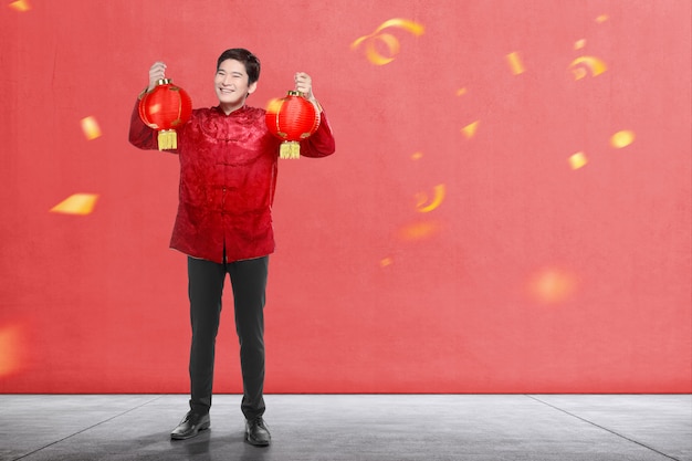 Een Aziatische Chinese man in een cheongsam-jurk met Chinese lantaarn