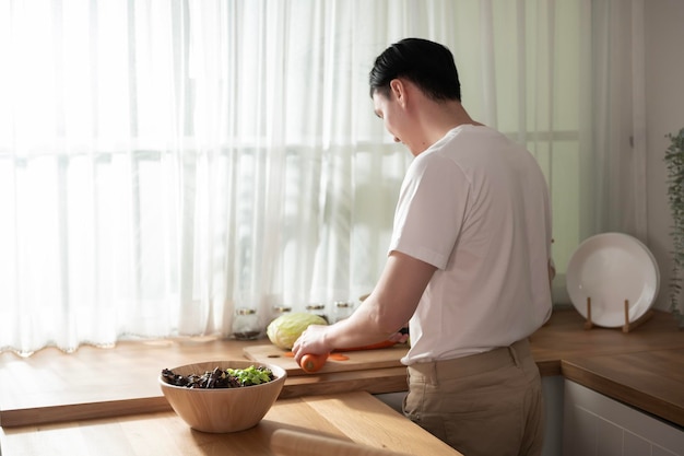 Een Aziatische jongeman die kookt en ontbijt bereidt met gezond voedsel