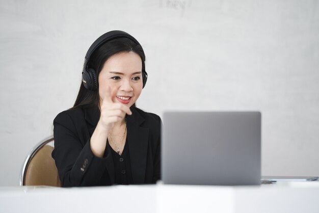 Een Aziatische lerares van middelbare leeftijd woont online met laptop op de universiteit