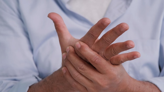 Foto een aziatische man heeft tintelingen en gevoelloosheid in zijn hand waardoor beriberi