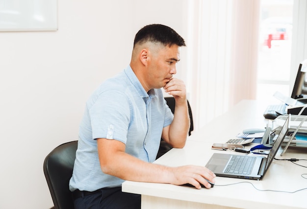 Een Aziatische man werkt op een computer, de student bestudeert het online bedrijfsconcept van technologische apparaten