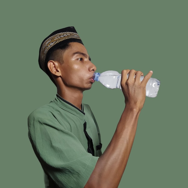 Foto een aziatische moslim voelt dorst vanwege het hete weer tijdens het vasten geïsoleerde groene achtergrond