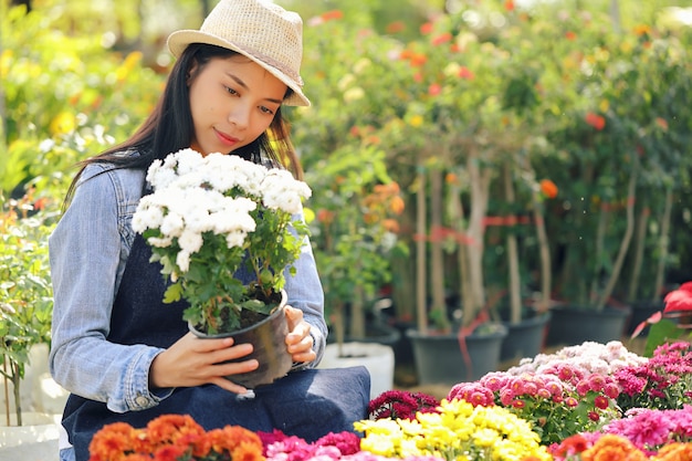 Foto een aziatische vrouw die eigenaar is van een bloementuinbedrijf, telt de bloemen in overeenstemming met de bestelling van de klant.