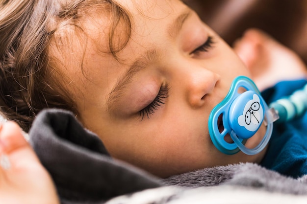 Foto een baby die heerlijk slaapt met blauwe fopspeen