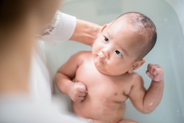 een baby die met hij moeder baadt